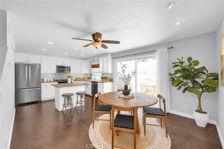Dining area with detailed lighting upgrades overlooks bright outdoor back patio space.