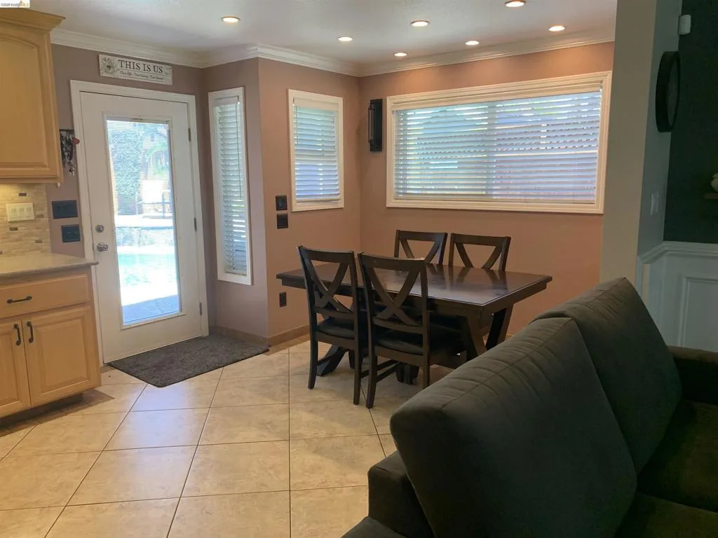Dining area featuring tile flooring, recessed lighting, and a large window with horizontal blinds