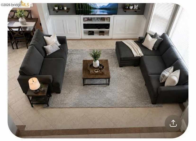 Open-concept living area with tile flooring and a built-in media console featuring white paneling and open shelving