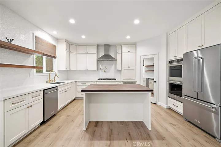 Spacious remodeled gourmet kitchen with black walnut butcher block countertop on kitchen island
