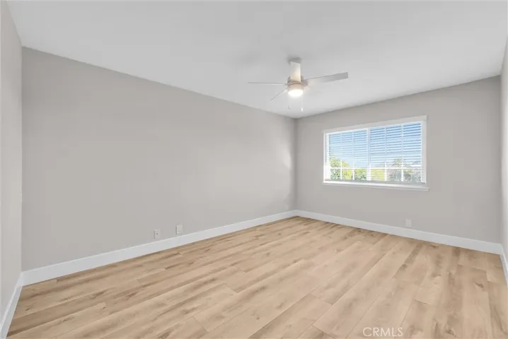 First bedroom featuring abundant natural light and hardwood floors.