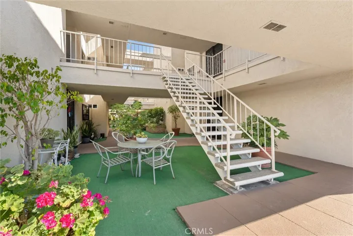 Landscaped interior courtyard with patio seating and stair access