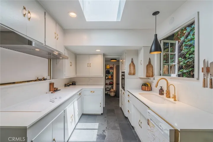 Refinished kitchen blends historic character with modern convenience, enhanced by custom lighting and thoughtful design updates.