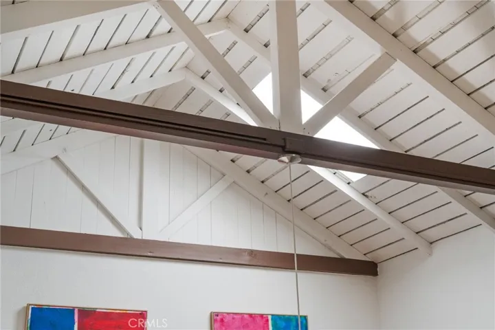 Original redwood framing and dramatic ceiling volume showcase the craftsmanship and character rarely found in contemporary homes.