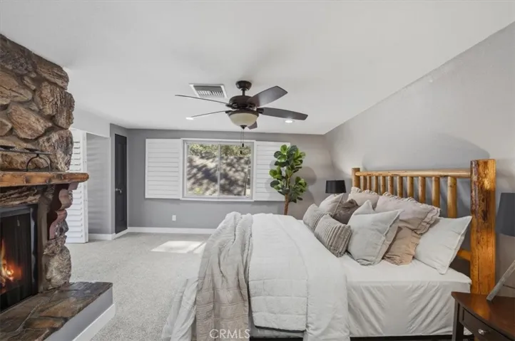 Primary bedroom with fireplace and deck