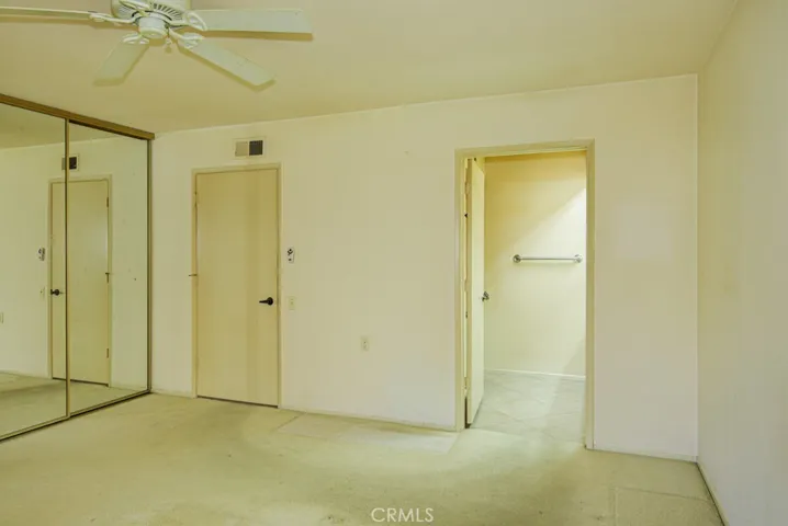 Another view of the primary bedroom suite. Entrance to to the primary bathroom at right.