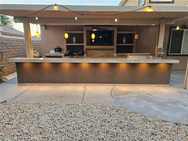 Lighted bar top on the outdoor kitchen, with TV