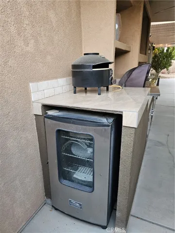 Smoker and pizza oven in outdoor kitchen