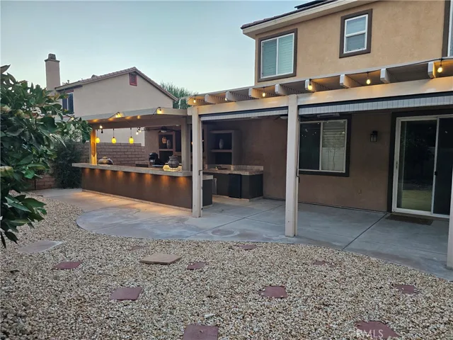 Outdoor kitchen and Rear patio are covered. Rear patio has rolling sunscreens to keep it cool