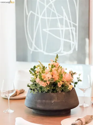 Hardwood table with place settings, centered by a dark gray decorative bowl