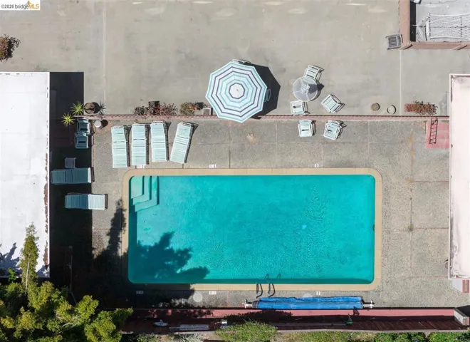 Rectangular swimming pool with integrated steps, surrounded by a concrete pool deck