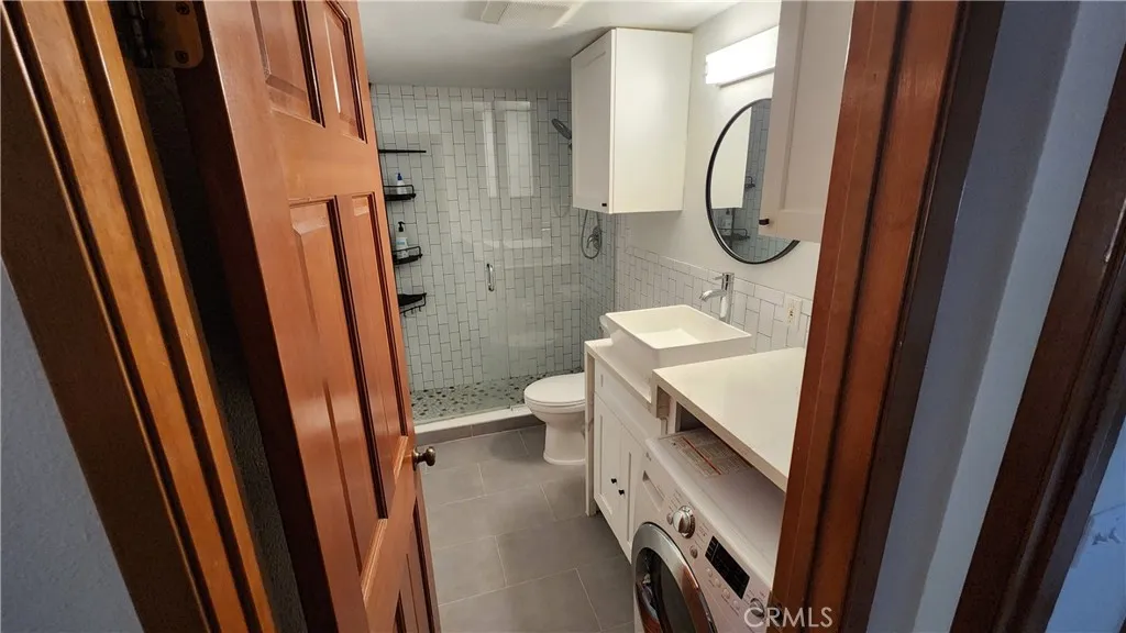 Updated Bath with European style combination washer/dryer laundry unit.