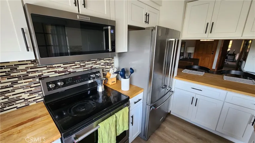 Newer tile backsplash, butcher block counters, cabinets, Stainless Steel Stove, Microwave and French Door Refrigerator