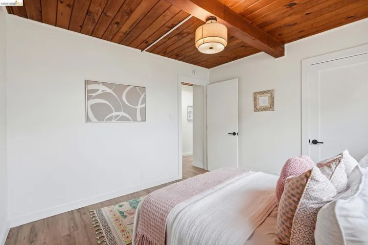 Room with a wood-finish plank ceiling and exposed beams