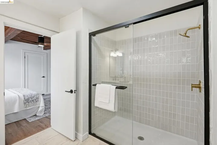 Walk-in shower with clear glass enclosure and contrasting black frame