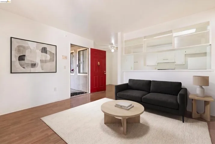 Living area featuring wood-finish flooring and a red paneled entry door