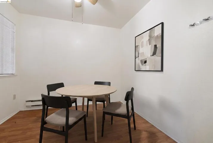 Room featuring wood-finish flooring, a window with blinds, a ceiling fan, and white painted walls