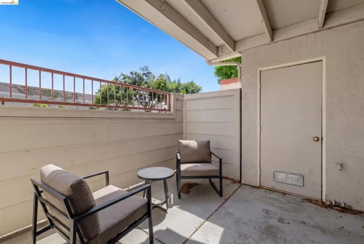 Private outdoor patio space featuring a concrete surface and a privacy wall