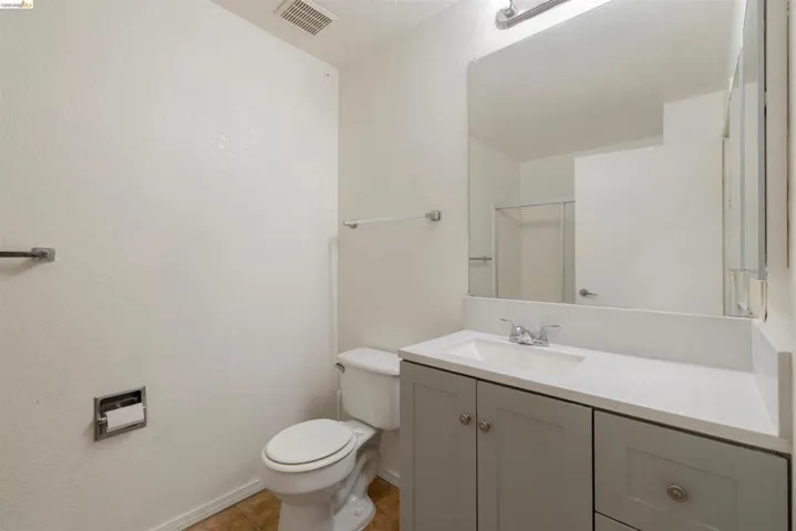Bathroom featuring a vanity with a white countertop, undermount sink, and light gray cabinetry