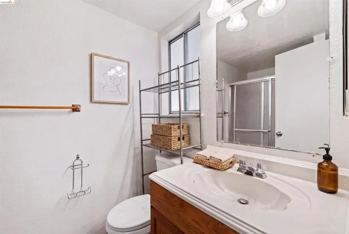 Bathroom featuring a wood-finish vanity with an integrated sink and chrome faucet