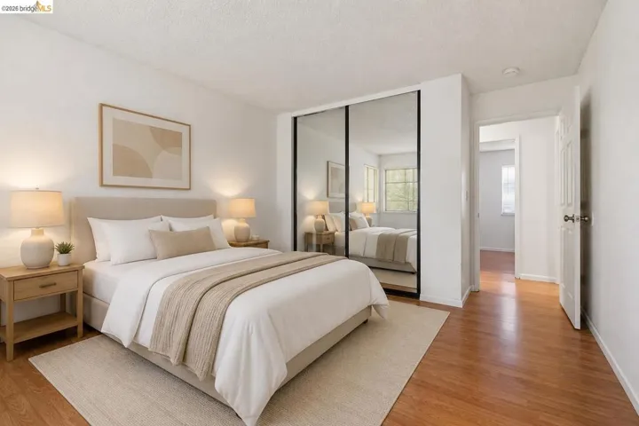 Bedroom featuring wood-finish flooring, mirrored closet doors, and recessed lighting