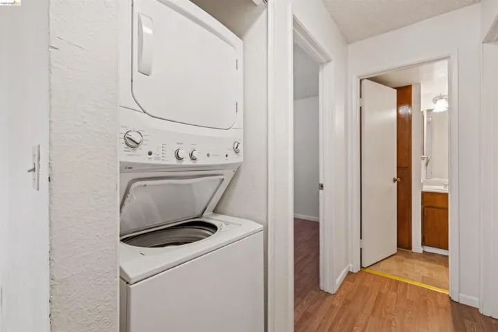 Dedicated laundry closet featuring a white stacked washer and dryer unit