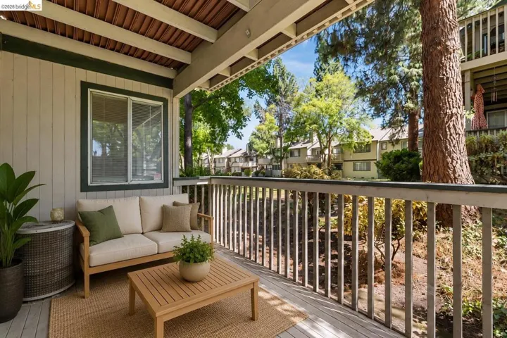 Covered outdoor patio featuring a slatted wood ceiling, painted railing, and durable exterior siding