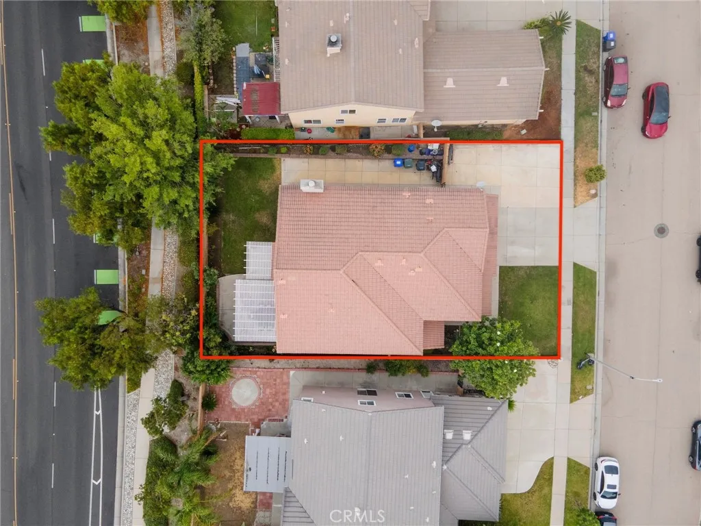 Aerial view showcasing the home's tile roofline, lot layout, and surrounding neighbors.