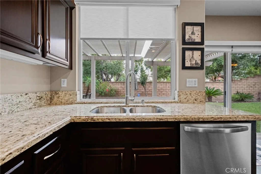 Kitchen sink overlooks the backyard, framed by a large window with natural light.