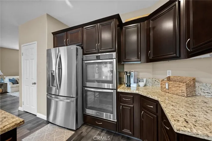 Well-equipped kitchen featuring a stainless refrigerator and built-in double ovens.