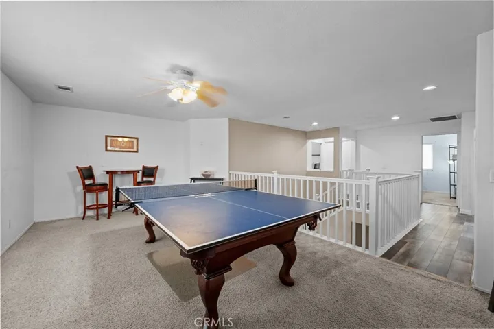 Versatile upstairs loft offers space for a game room, media area, or additional living space. The pool table and accessories are included in the sale.