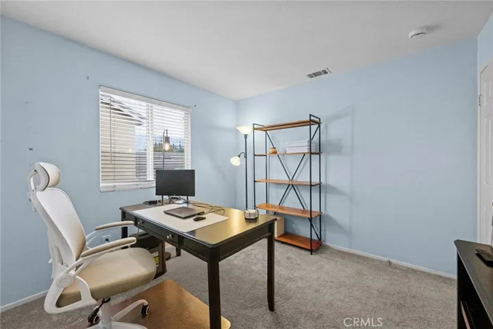 North-facing bedroom with plush carpet is currently set up as a home office, ideal for remote work.