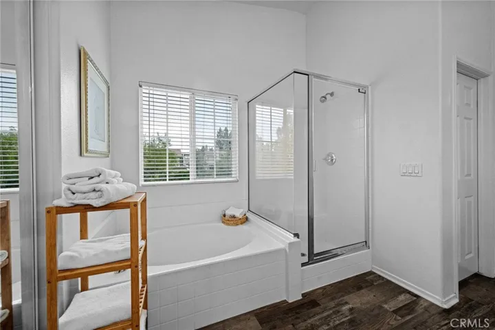 Soaking tub and separate glass-enclosed shower complete the spa-like primary bath with dual walk-in closets and private water closet.