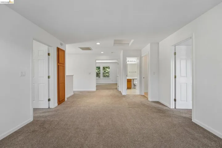Carpeted hallway with white walls and trim