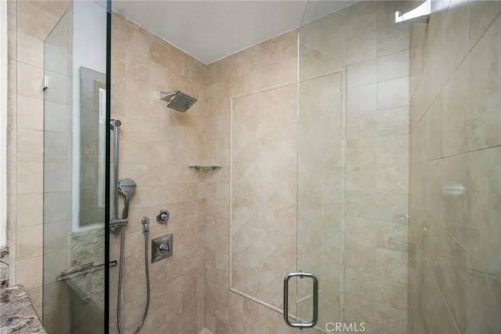 Beautifully tiled walk-in shower with frameless glass enclosure.