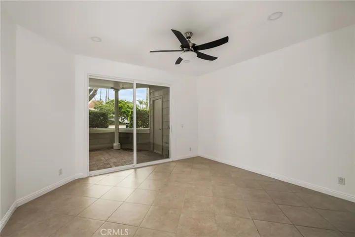 Large primary bedroom with ceiling fan and sliding door to the patio.