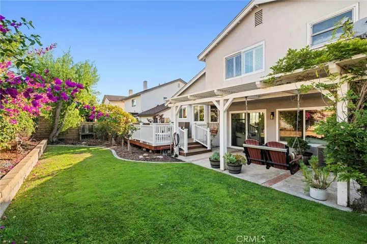 The beautifully landscaped yard offers lush lawn areas, mature gardens, and plenty of room to play or unwind in privacy