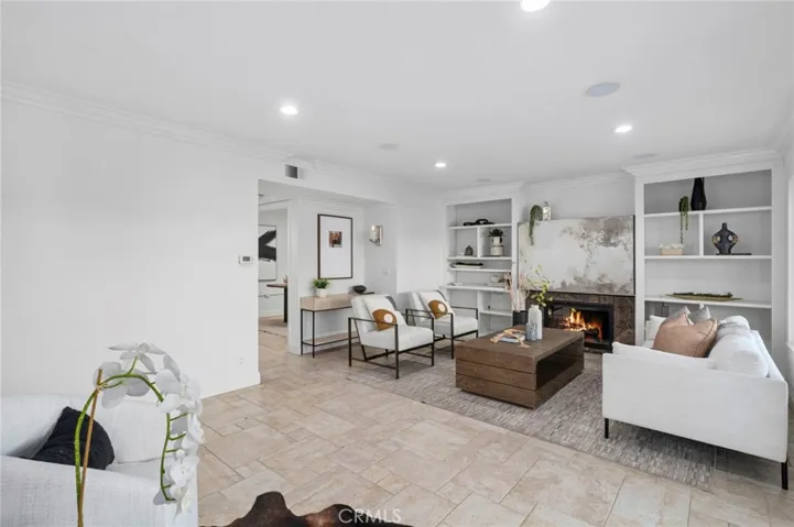 Spacious family room features a cozy fireplace, custom built-in shelving, and oversized sliding glass doors for exceptional indoor-outdoor living