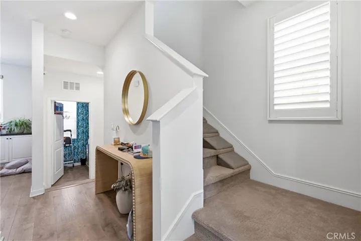 Hallway looking towards laundry room and upstairs to bedrooms.