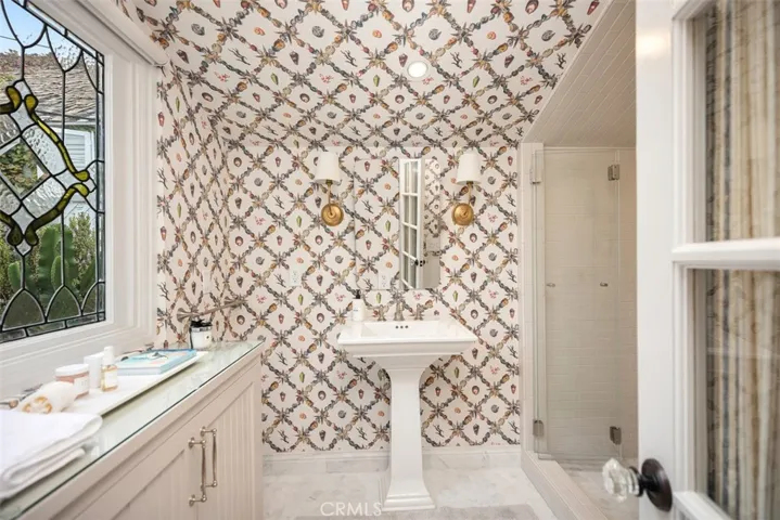 First full bath off of living room space with gorgeous wall paper and attention to detail. Very spa like.