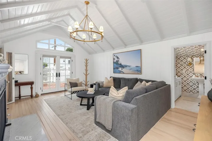 White oak flooring throughout home and Ralph Lauren chandelier focal point in living room.