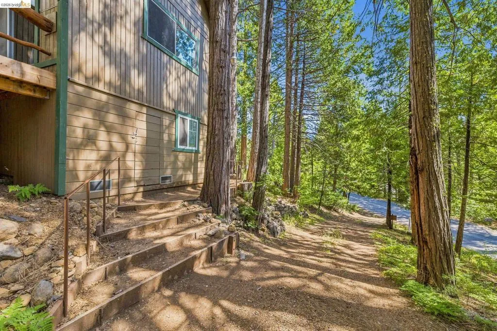 House exterior with wood siding, green trim windows, and a wood deck