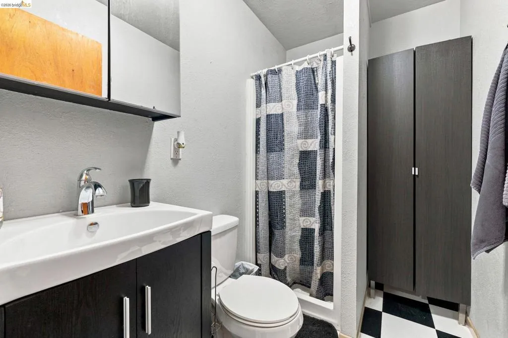Bathroom featuring a dark wood-finish vanity with an integrated white sink, a chrome faucet, and a wall-mounted mirrored medicine cabinet
