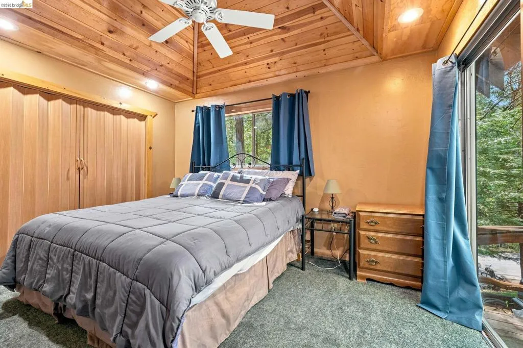Bedroom with vaulted wood-paneled ceiling, ceiling fan, and recessed lighting
