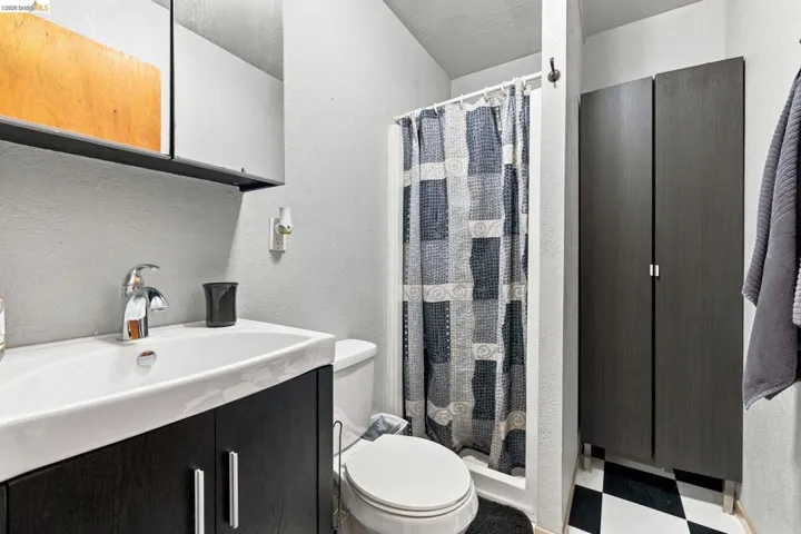 Bathroom featuring a dark wood-finish vanity with an integrated white sink, a chrome faucet, and a wall-mounted mirrored medicine cabinet