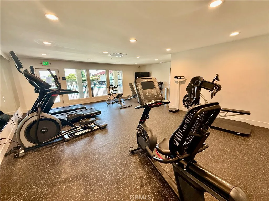 Clubhouse gym with view of pool & spa