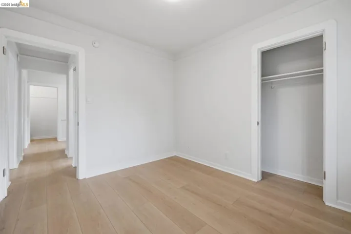 Room featuring wood-finish flooring, white walls, and bright overhead lighting