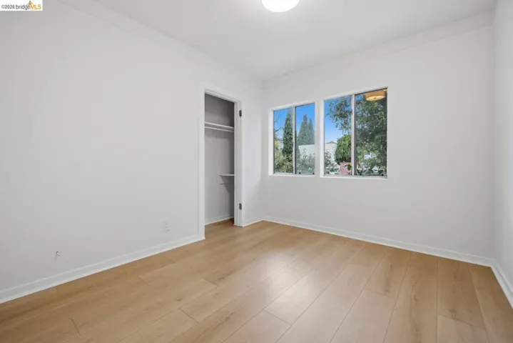 Room featuring light wood-finish flooring, white baseboards, and a neutral wall color