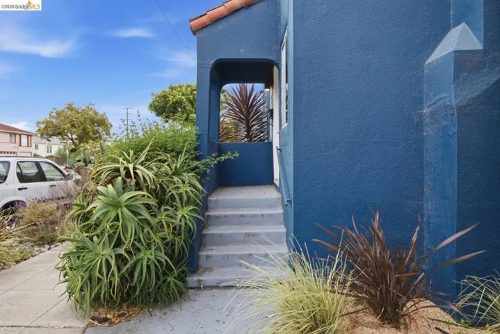 Stucco exterior featuring a tiled roof and recessed entry