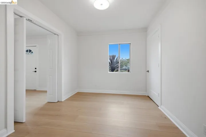 Light wood-finish flooring complements crisp white walls in this interior space